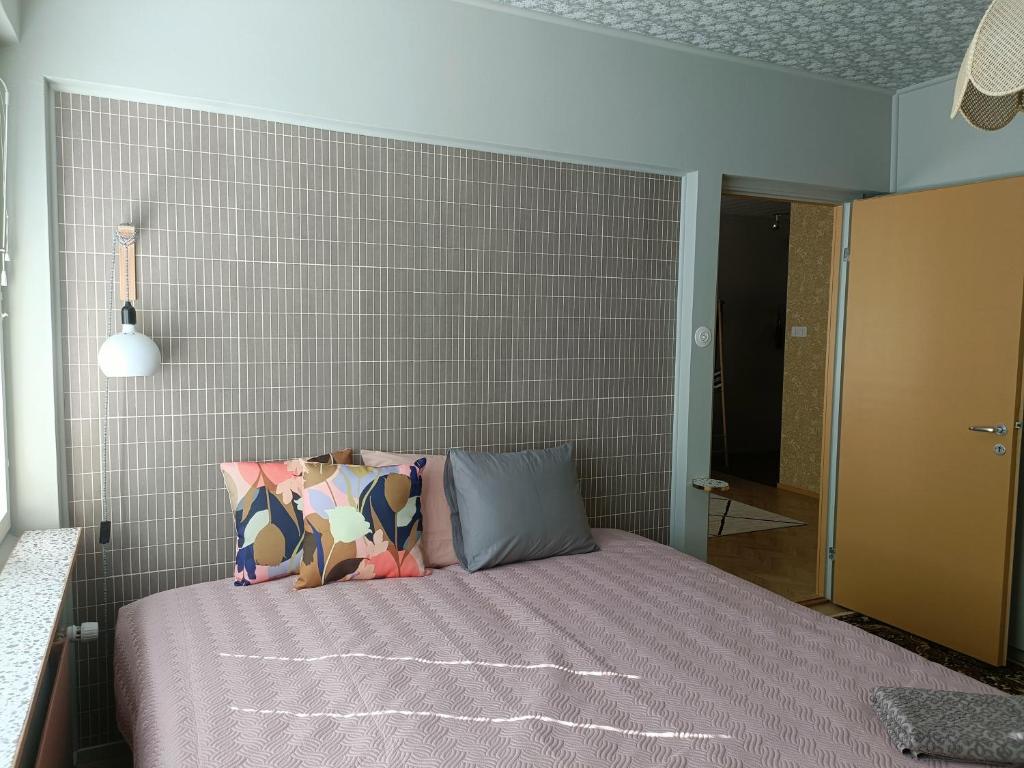 罗威萨Hieno kaksio keskustassa rauhallisella alueella的一间卧室设有一张床和砖墙