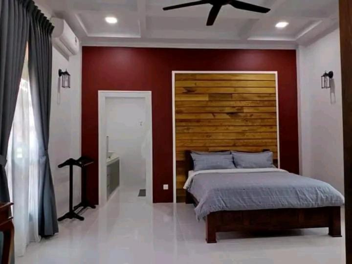 瓜拉丁加奴Inap Kota sang rimba的一间卧室配有一张大床和木制床头板