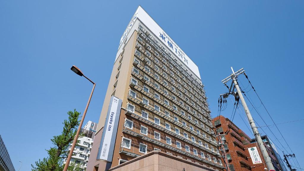 大阪Toyoko Inn Shin-osaka Higashi-mikuni Ekimae的前面有起重机的高楼