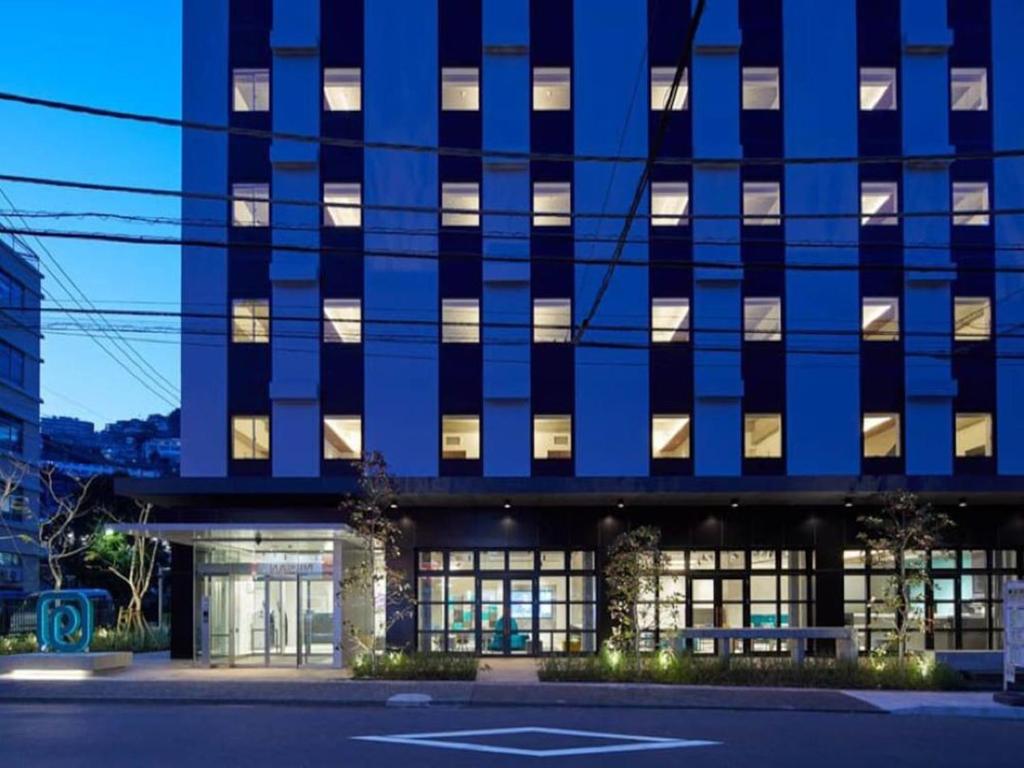 热海熱海王子智能酒店(Prince Smart Inn Atami)的一座带灯光的大型蓝色建筑