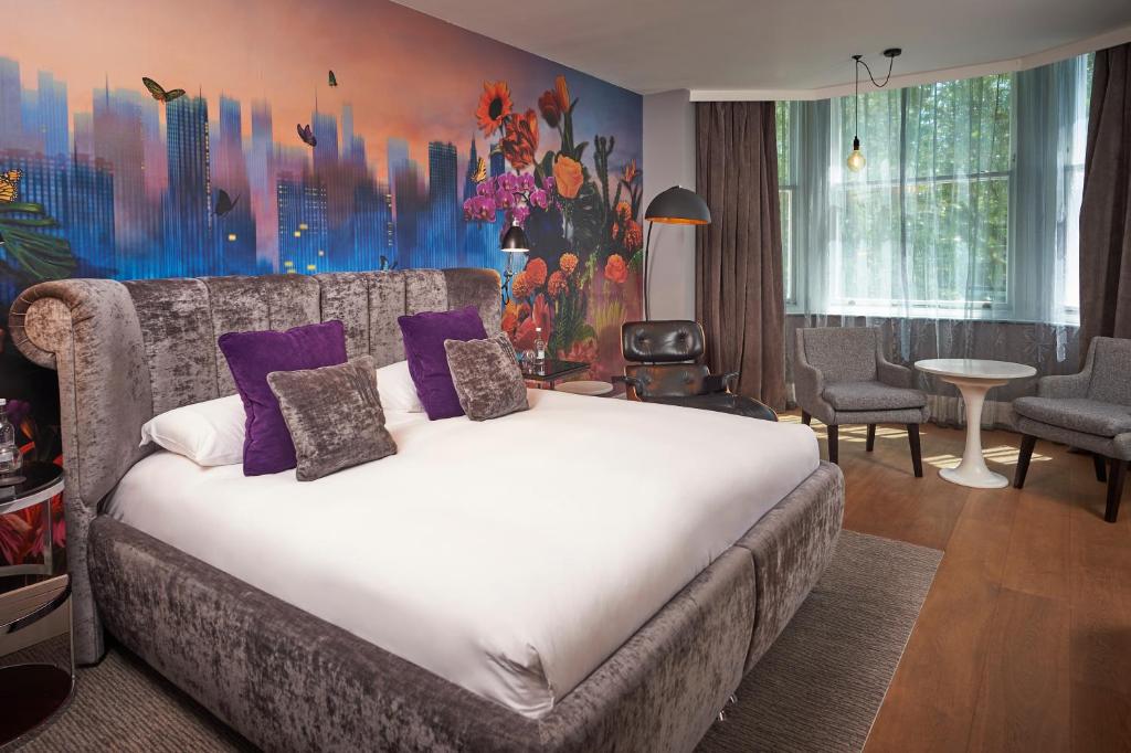 伦敦马尔马逊伦敦酒店的一间卧室配有一张带紫色枕头的大床