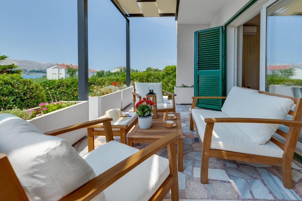 帕格Villa Silencia的阳台配有白色家具,享有海景。