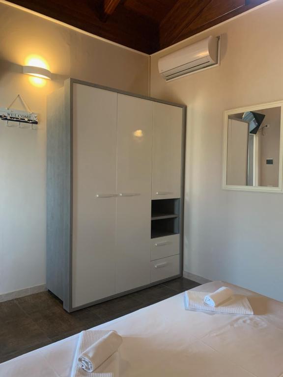 玛格丽塔萨沃亚Spiaggia Le Dune Residence的卧室配有白色大衣柜和1张床