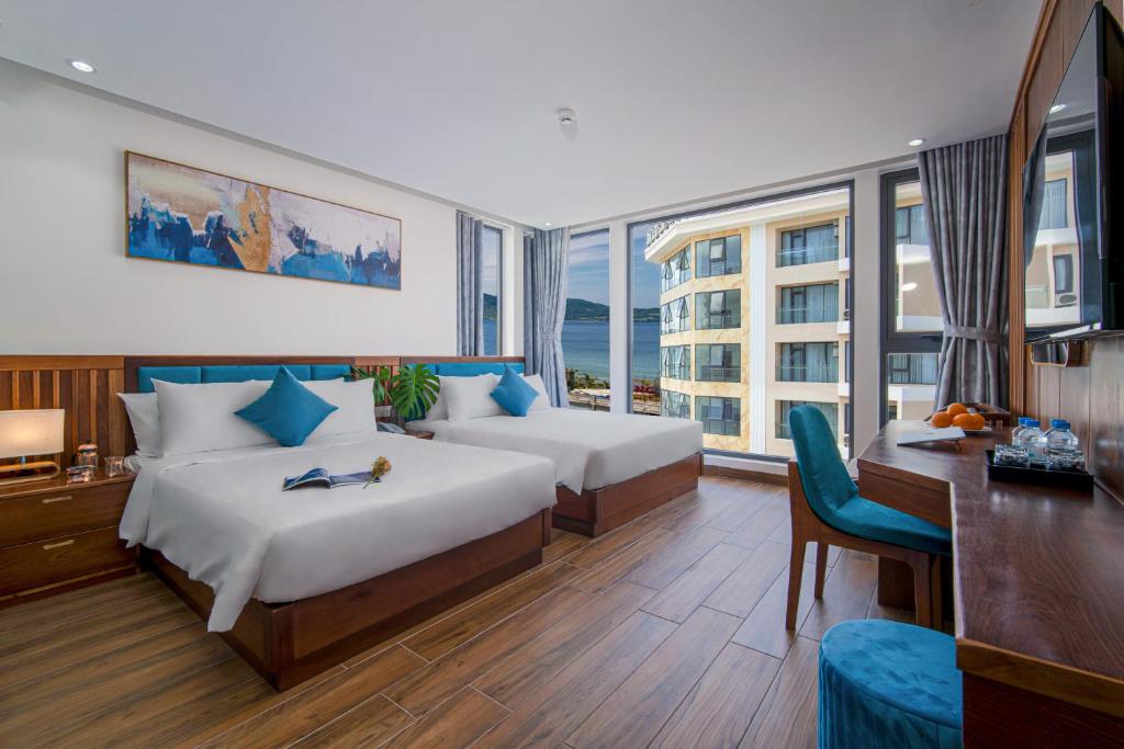 岘港Sea Wind Hotel by THG的酒店客房配有两张床、一张书桌和一张书桌。