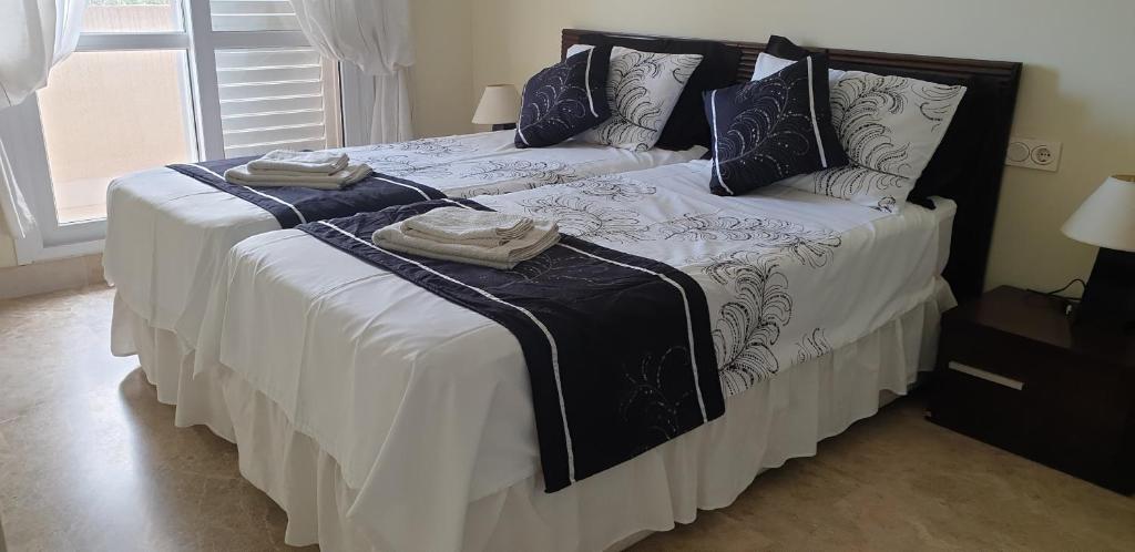 阿尔梅利马Luxury apartment in central Almerimar with Free Secure Parking的一间卧室配有一张床,上面有两条毛巾
