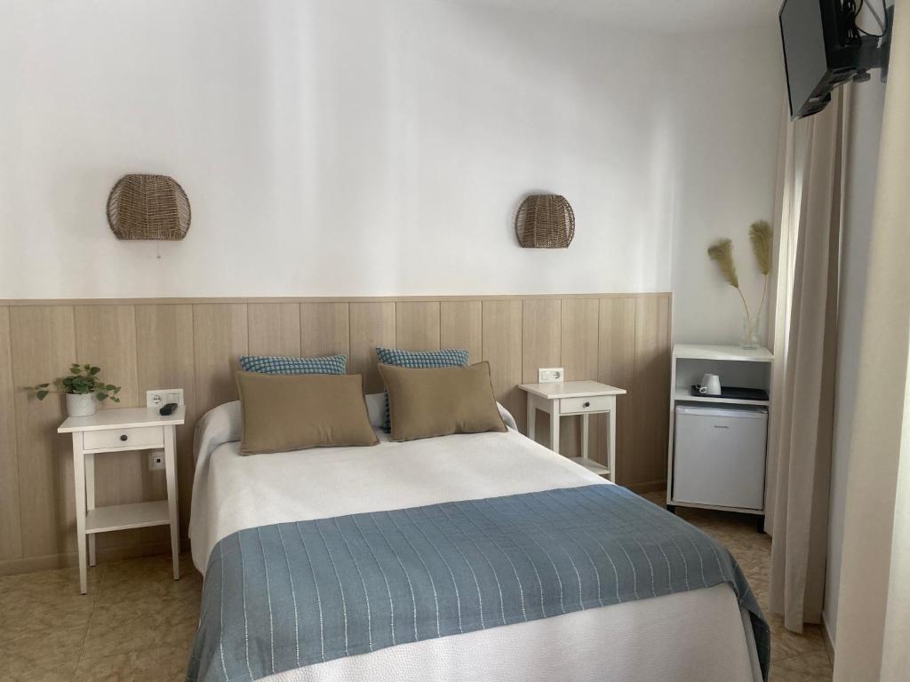 内尔哈安达卢西亚旅馆的一间卧室配有一张大床和两张桌子