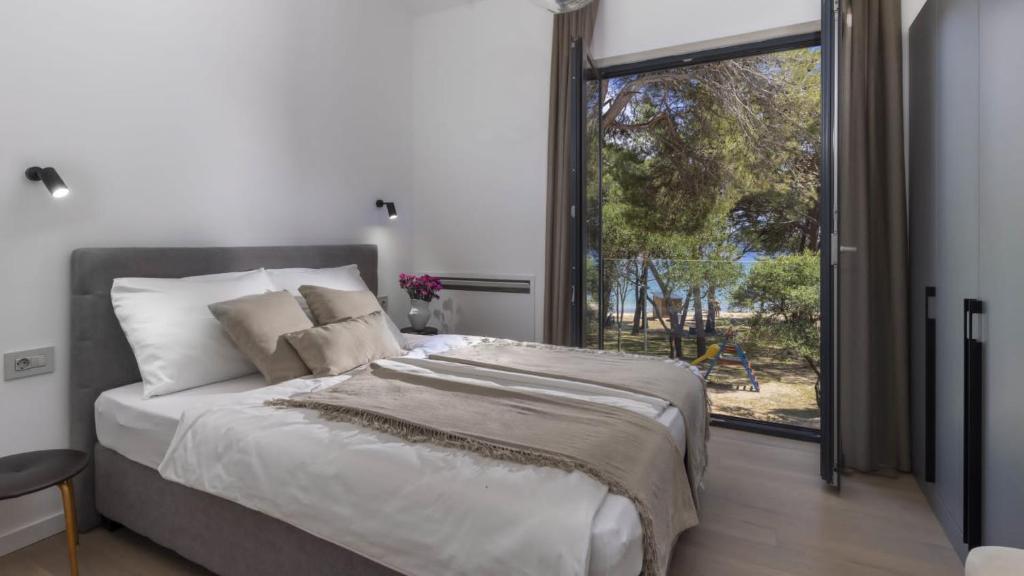 木洛希尼Mare Solis Pinea的一间卧室设有一张大床和一个大窗户