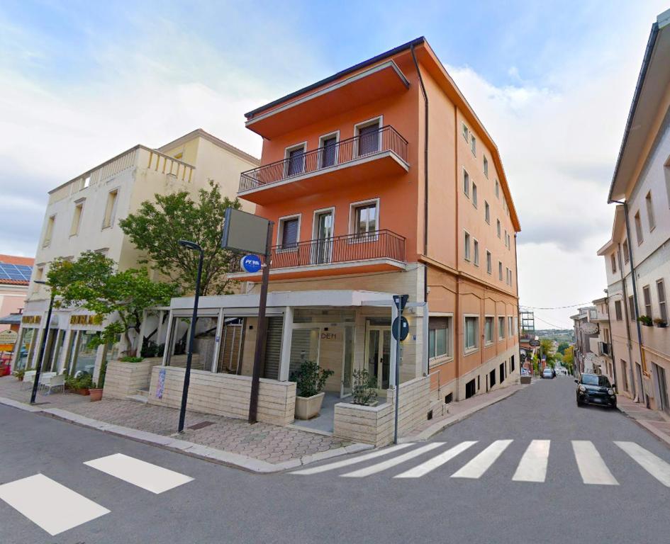 圣乔瓦尼·罗通多HOTEL HOUSE GARGANO的街道边的橙色建筑