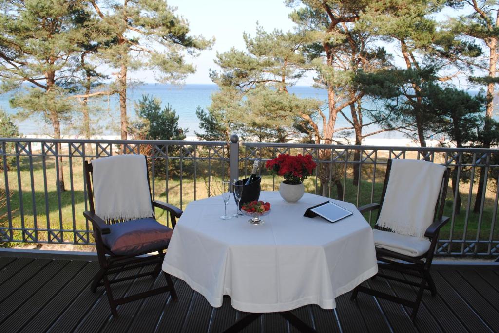 宾茨Panorama-Meerblick in der Villa Atlantic mit Strandkorb am Strand的海洋甲板上的一张桌子和两把椅子