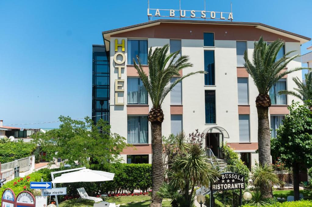 奥托纳Hotel La Bussola的一座楼前有棕榈树的酒店