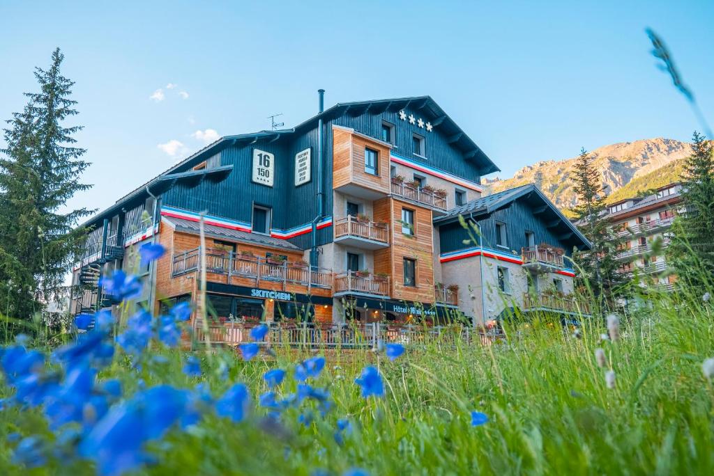 瓦尔Hôtel 16 | 150 Montagne & Spa Nuxe的蓝色花丛中一座建筑