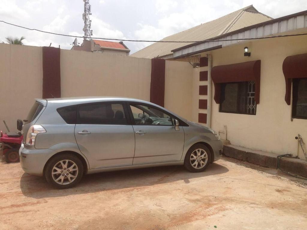 贝宁城Charming 2-Bed Cottage in Benin City的停在房子前面的银色汽车