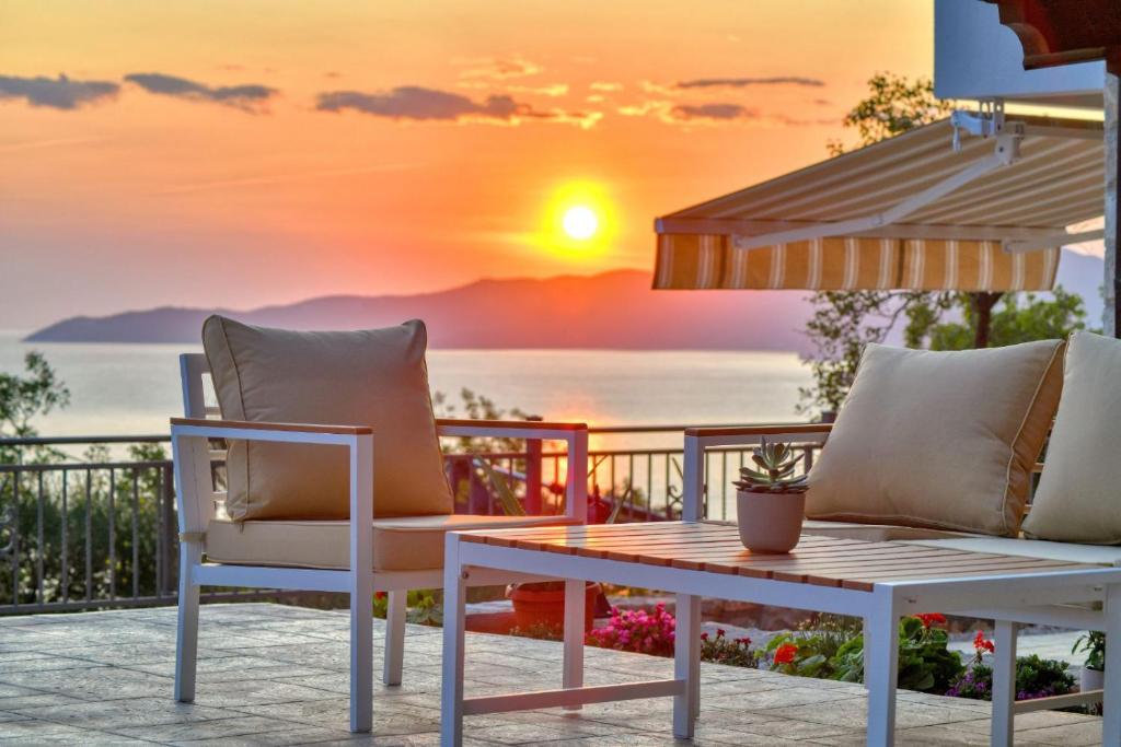 布德瓦Seaview Villa Lavanda with pool的阳台的桌椅享有日落美景