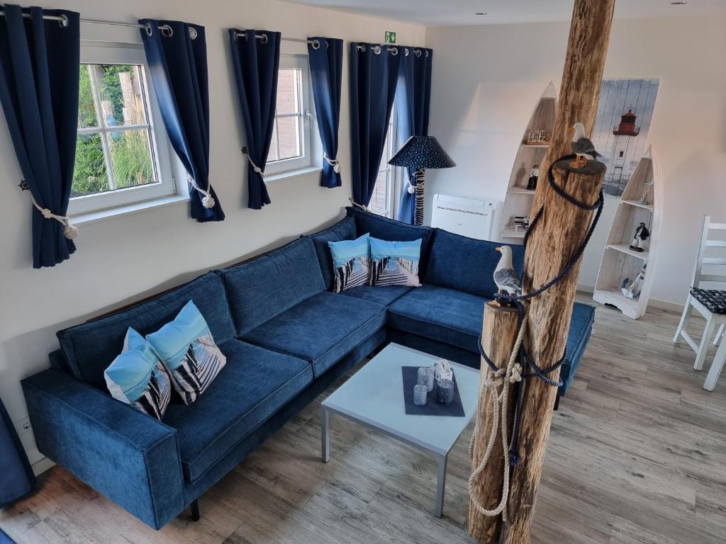 坎珀兰Vakantiehuis de Ankerplaats的客厅配有蓝色窗帘的蓝色沙发