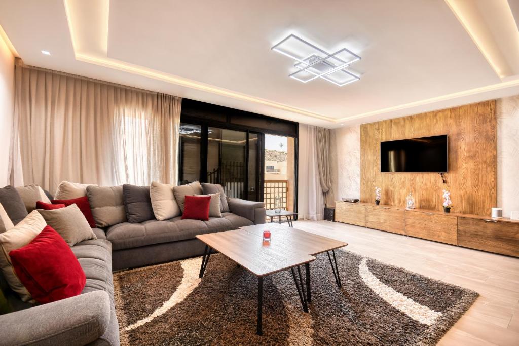 塔哈佐特Aya - Taghazout - T3 Duplex Luxe - 4 or 5 Px的带沙发和电视的客厅