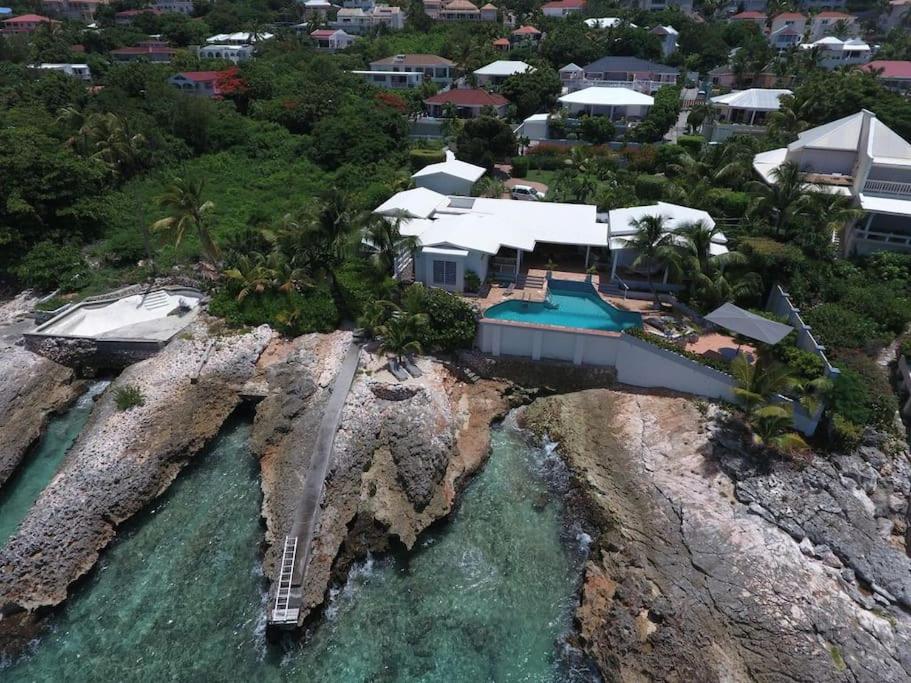 辛普森湾Ocean front villa, pool, private ocean snorkeling的岩石岛上房屋的空中景观