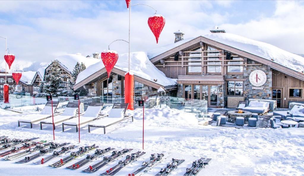 谷雪维尔Hotel Le K2 Altitude的一组滑雪板在小屋前的雪地里