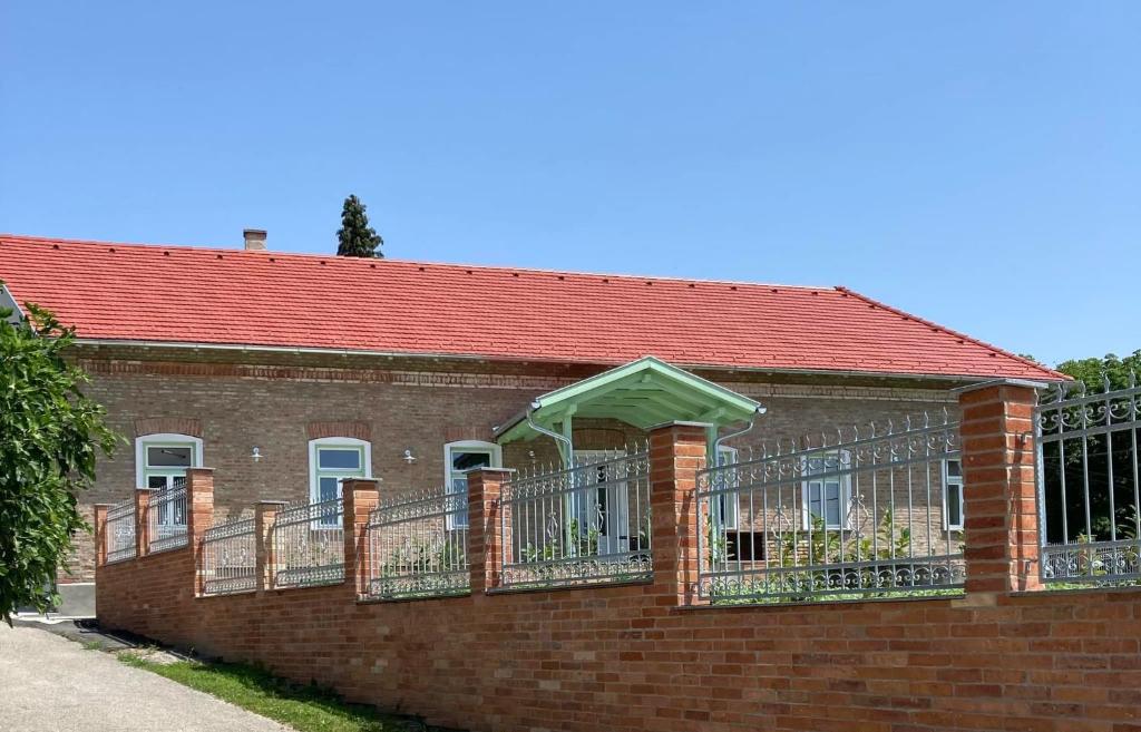 LengyeltótiKira Panzió的红屋顶砖楼和阳台