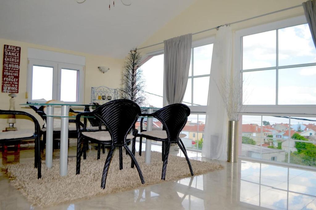 普莱克Wohnung mit Meerblick Romy的一间设有三把椅子和一张桌子的用餐室以及窗户。
