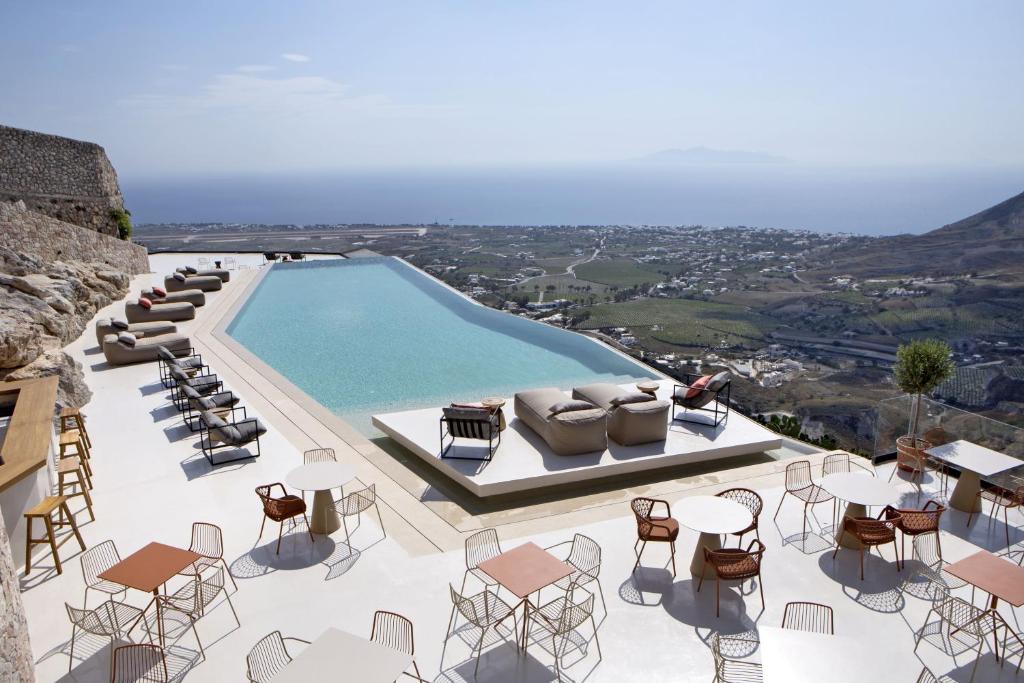 皮尔戈斯Elessa Hotel的享有带桌椅的游泳池的景致。