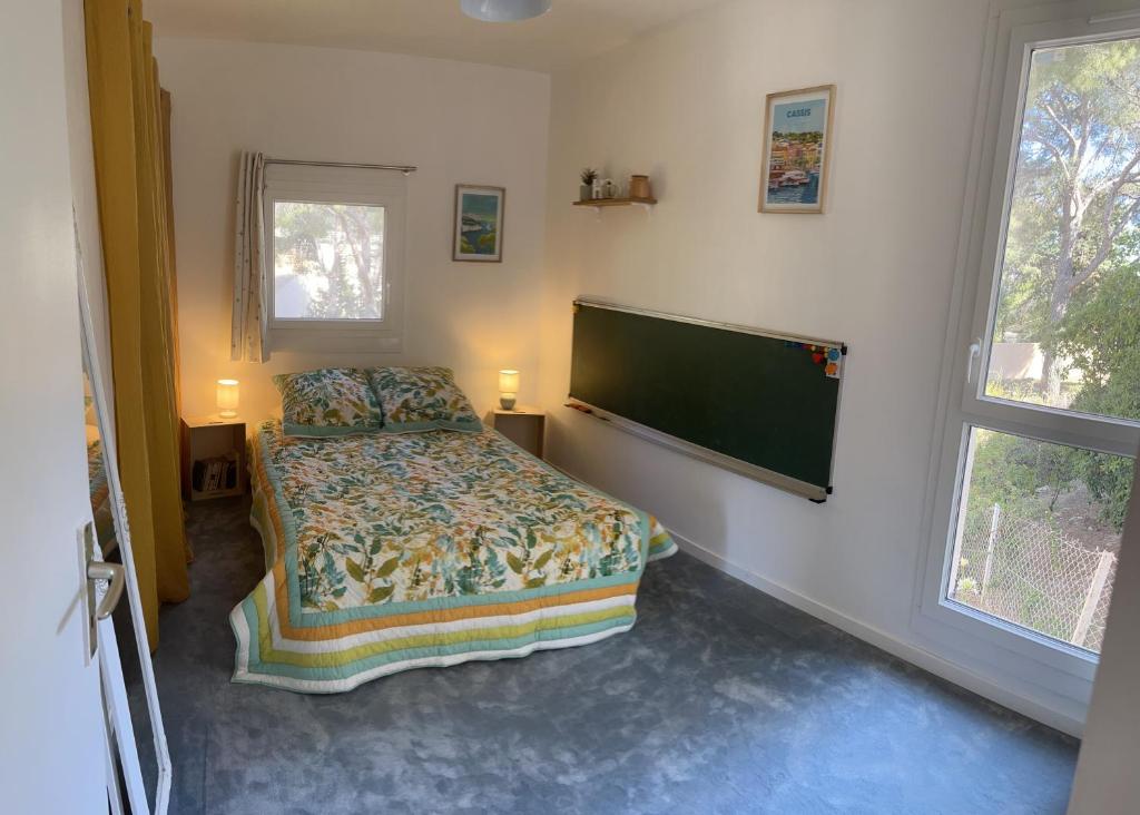 卡西斯Chambre double cassis的一间卧室配有一张床和一台平面电视