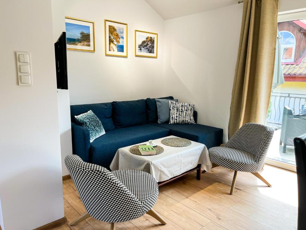 波德贝Apartamenty Zacisze 1的客厅配有蓝色的沙发和椅子