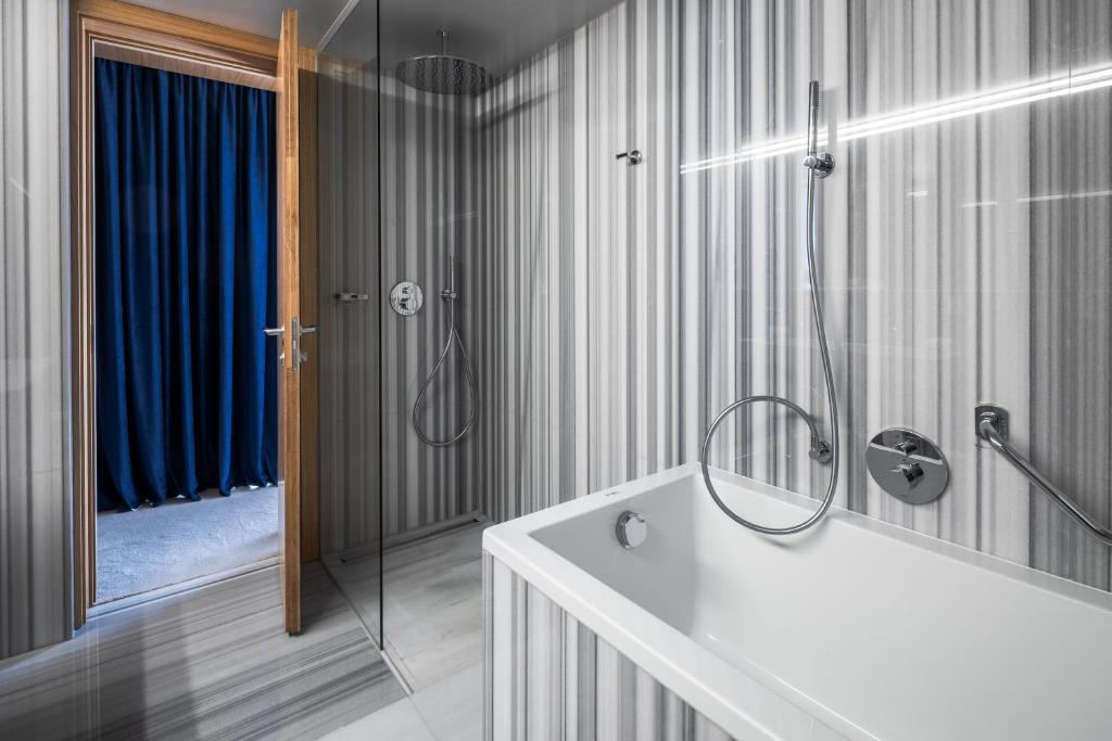 萨格勒布Met Boutique Hotel的带淋浴和白色浴缸的浴室