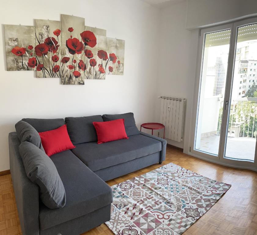 的里雅斯特CASA DENDI的客厅配有灰色沙发和红色枕头
