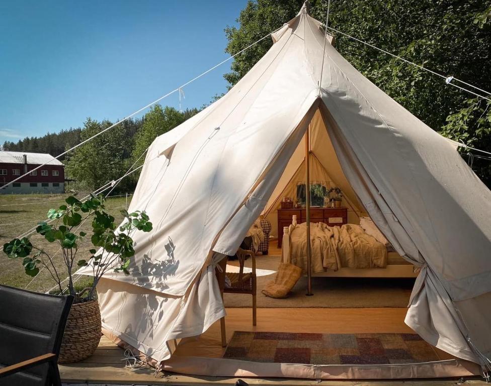 希恩Idyllisk glamping rett ved elven的大型白色帐篷,配有一张床