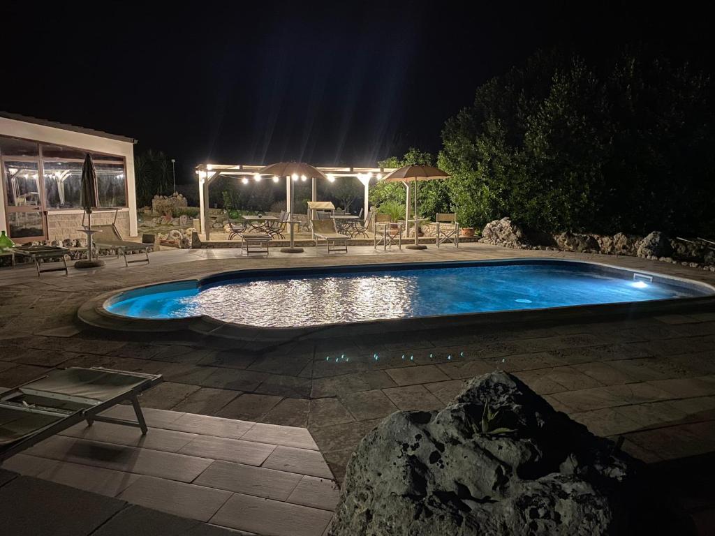 卡尔皮尼亚诺萨伦蒂诺Agriturismo Masseria Saittole的夜间在院子里的游泳池