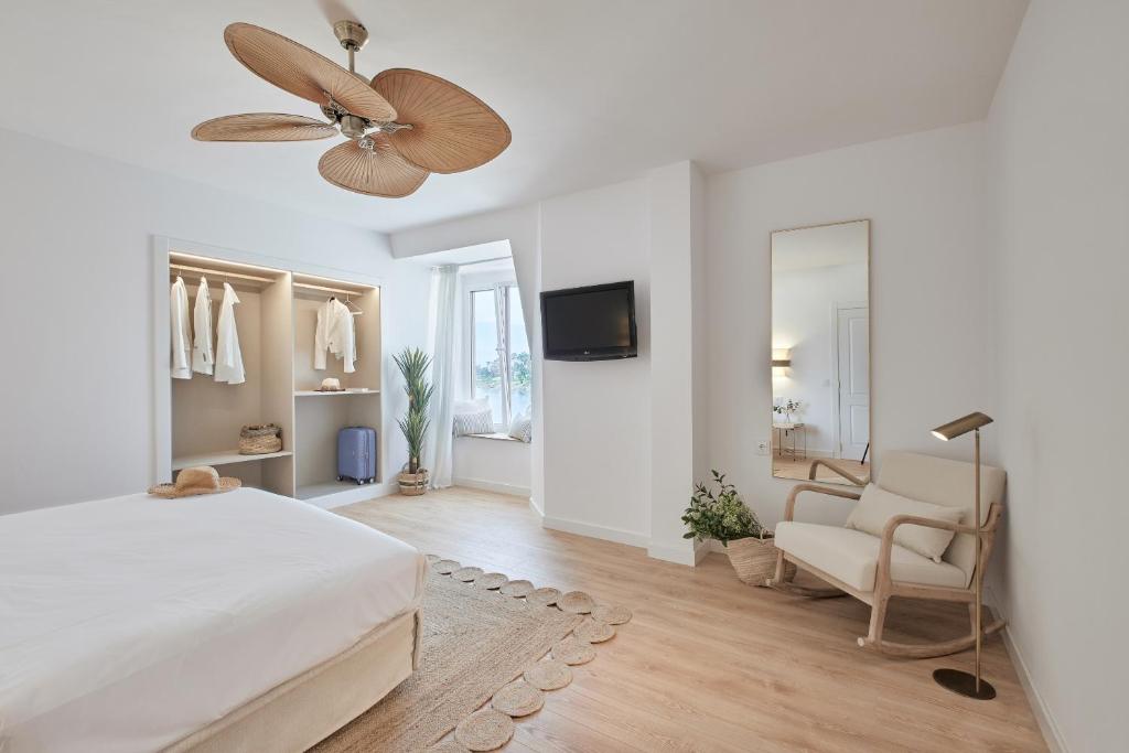 桑亨霍Hotel del Mar的白色卧室配有床和吊扇