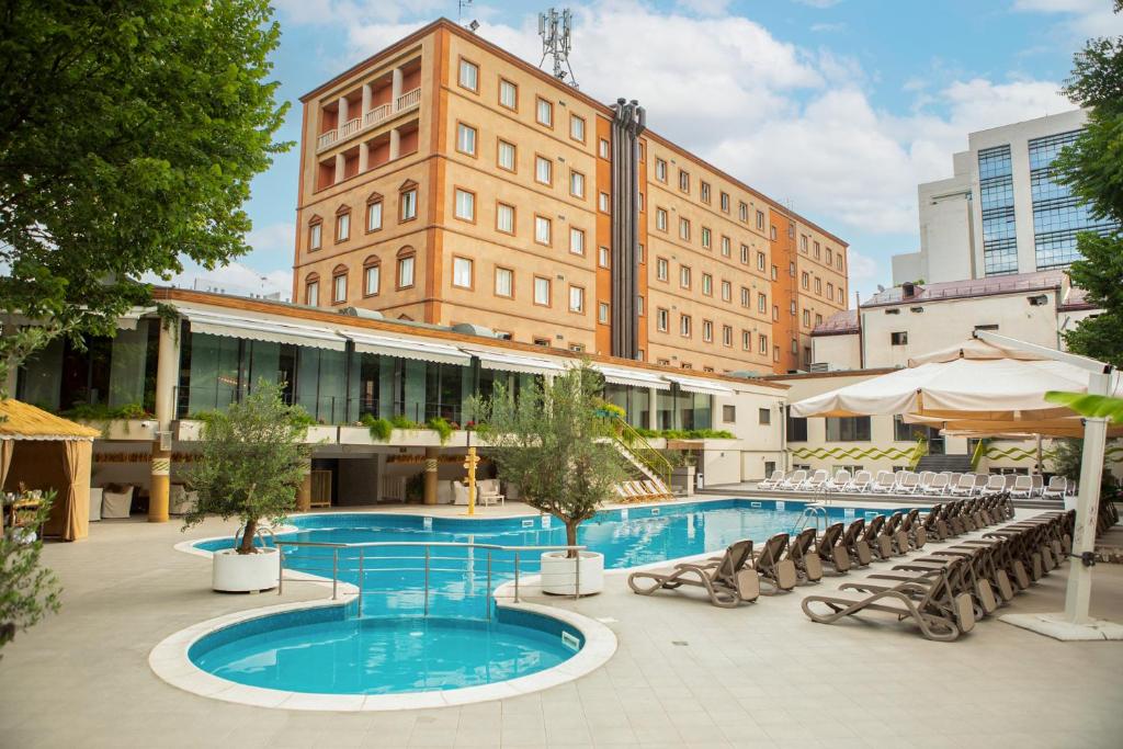 埃里温Best Western Plus Congress Hotel Yerevan的一座带椅子的大型游泳池和一座建筑
