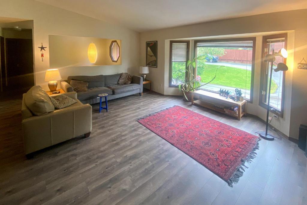安克雷奇Raspberry Retreat的带沙发和红色地毯的客厅