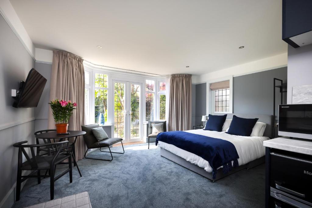 伯恩茅斯Cransley Apart Hotel的卧室配有一张床和一张桌子及椅子