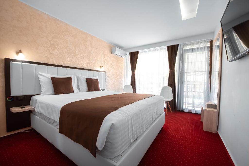 旧瓦马Km ZerO - Vama Veche的酒店客房,设有大床和红地毯