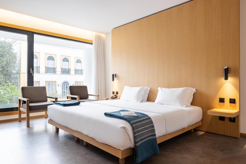 埃武拉埃武拉橄榄酒店的一间卧室设有一张大床和一个大窗户