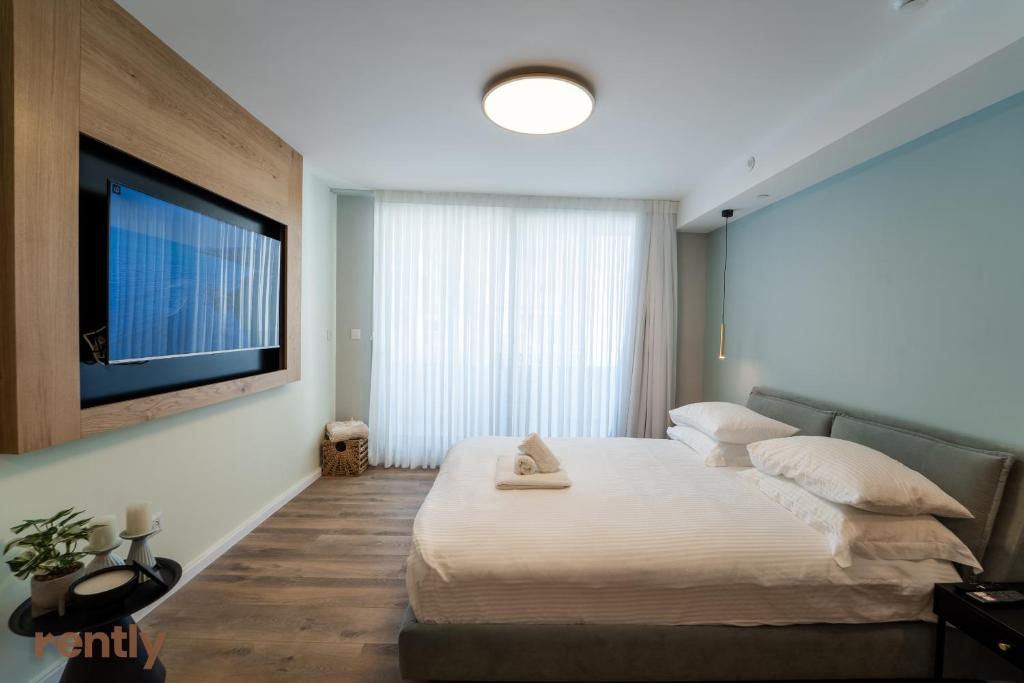 埃拉特Sea side "Tulip" apartment - by Rently的一间卧室配有一张大床和一台平面电视