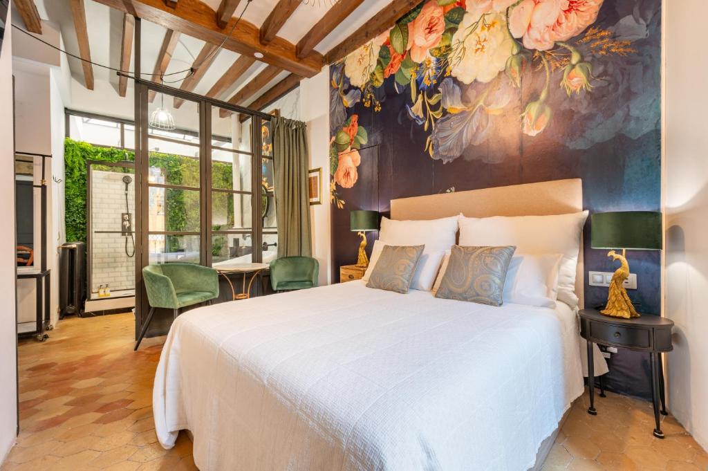 马略卡岛帕尔马Dog Admiral - Urban Guest House的卧室配有一张大床,墙上挂有绘画作品