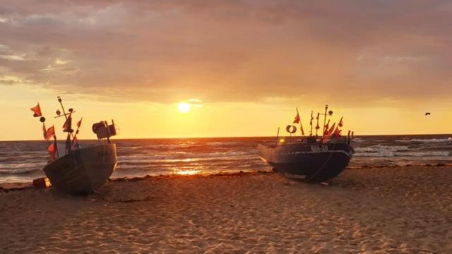 巴贝Ferienwohnung Gentzen的日落时分在海滩上坐两艘船