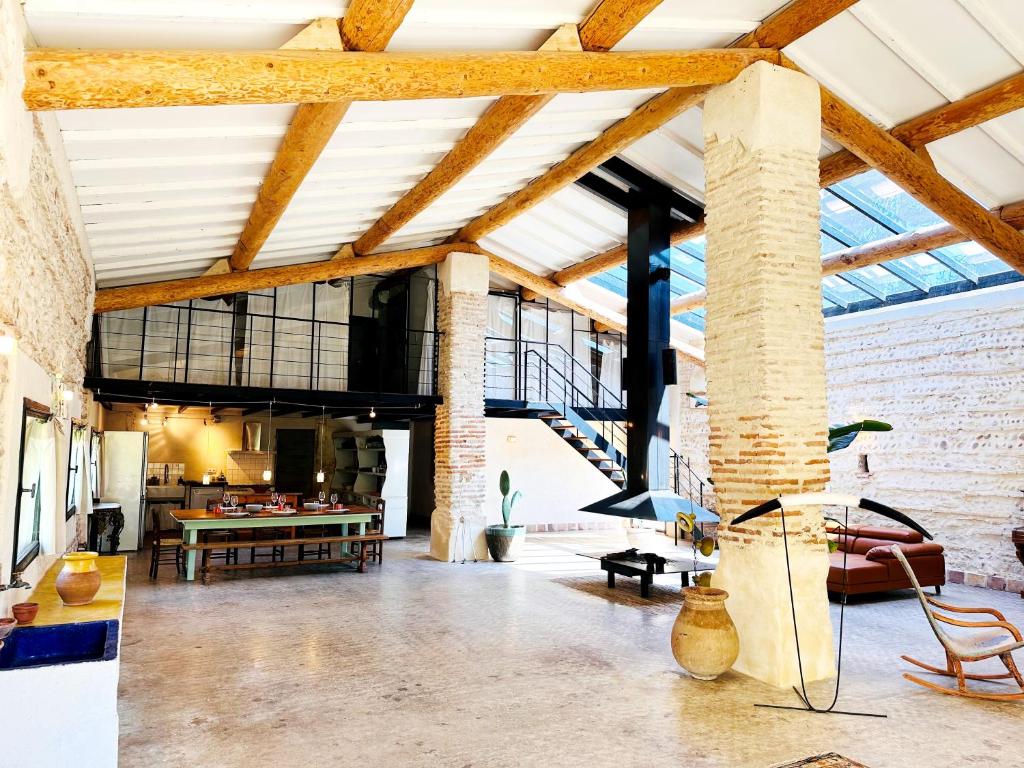 尼姆Magnifique Loft - Piscine - Tennis - Babyfoot的开放式客厅设有裸露的天花板和砖墙
