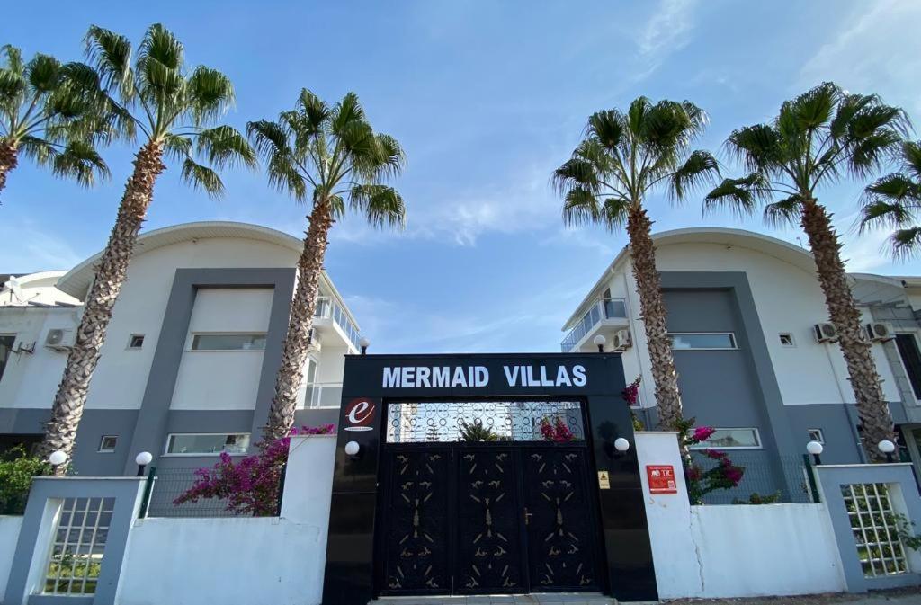 贝莱克ANTALYA BELeK MERMAİD VİLLAS的一座楼前有棕榈树的酒店