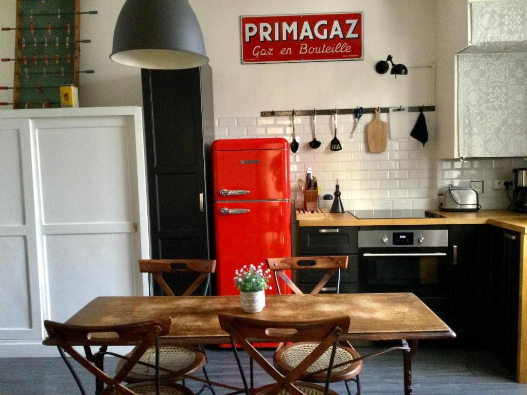 图尔L'APPART de 75 m², déco sympa à Tours的厨房配有桌子和红色冰箱