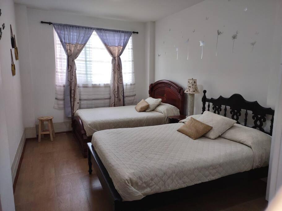 安巴托VISTA ÚNICA HERMOSO Mini Departamento en Ambato的一间卧室设有两张床和窗户。