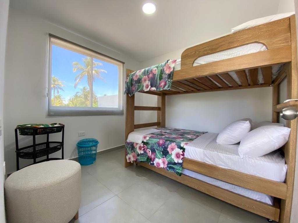 圣贝尔纳多德尔比恩托NAHIR apartamento de playa en condominio Palmar del viento的一间卧室配有两张双层床和椅子