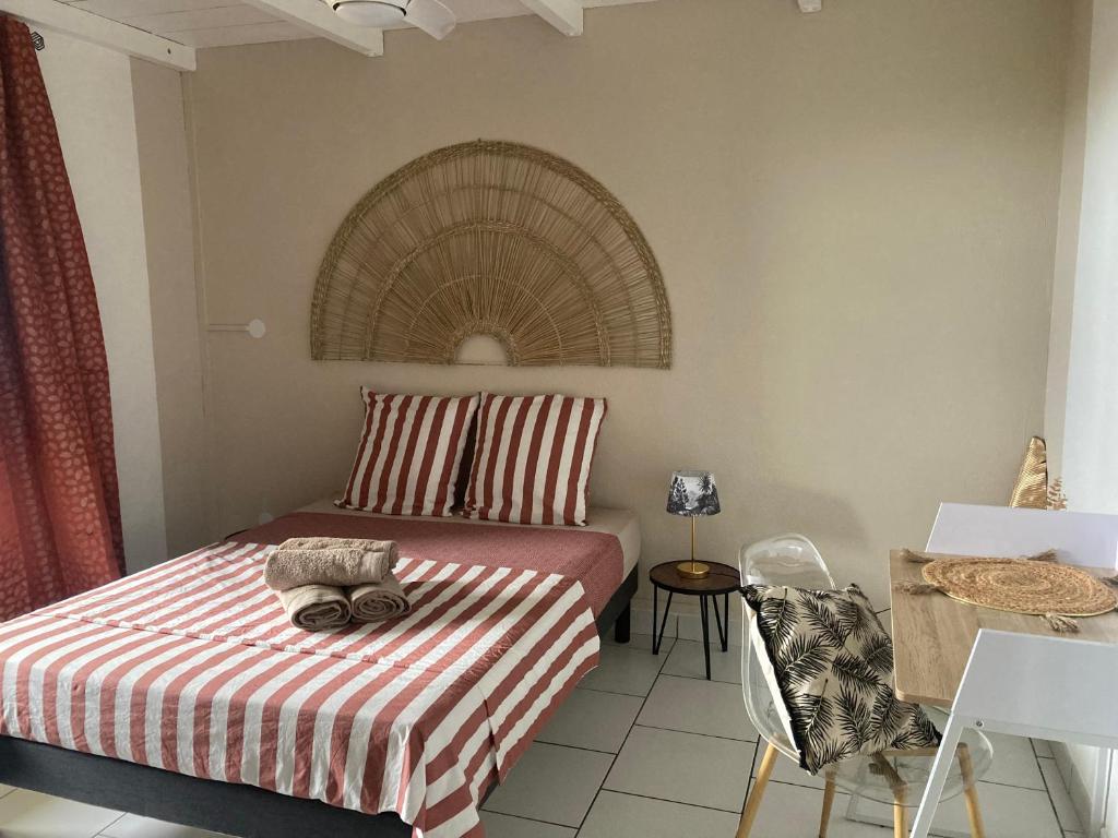 舍尔谢Maison avec spa et jardin的一间卧室配有一张带条纹毯子和桌子的床