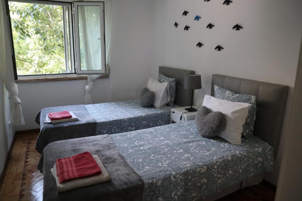 里斯本Sun House Belem -Free Paking and View Tower的一间卧室设有两张床和窗户。