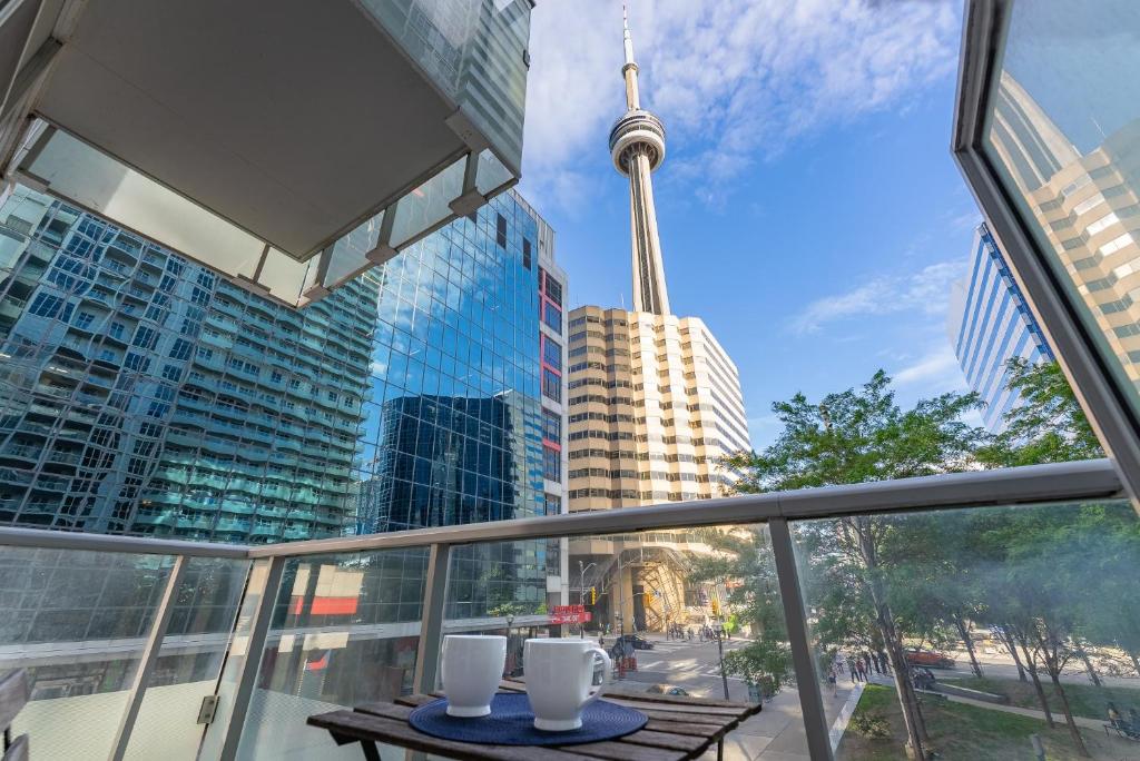 多伦多Luxury 2BR Apt-CN View-Free Parking-Roof Top Pool的阳台配有桌子,享有Cn塔的景致。