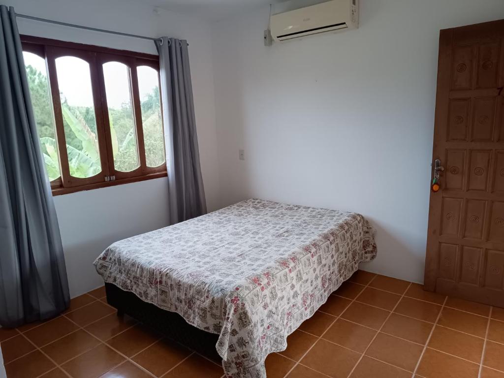 因比图巴POUSADA DA PONTE IBIRAQUERA的一间卧室设有一张床和一个窗口