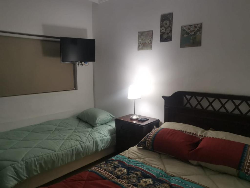 索瓦马A wonderful stay at the Dead Sea的一间卧室设有两张床和一张桌子上的台灯。