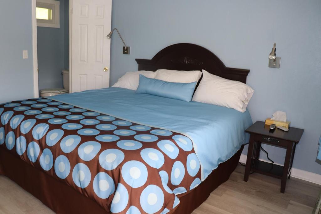 Hitching Post Motel的一间卧室配有一张带蓝色和白色棉被的大床